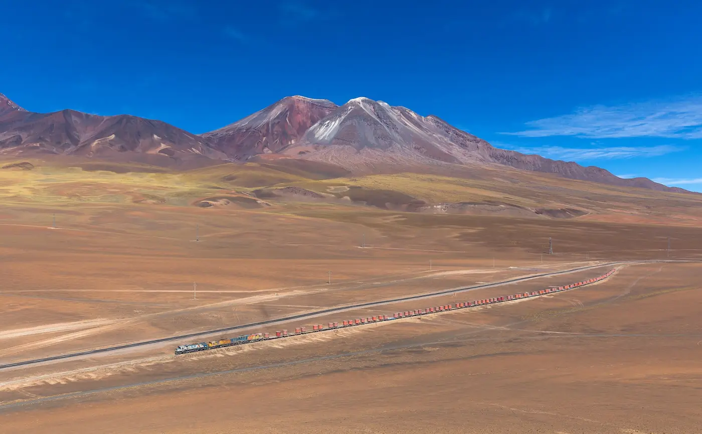 Tren del FCAB en la subida al altiplano, con volcán de fondo